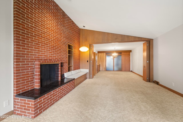 unfurnished living room featuring light carpet, vaulted ceiling, and a notable chandelier