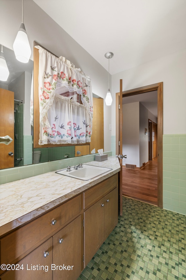 bathroom with vanity and tile walls