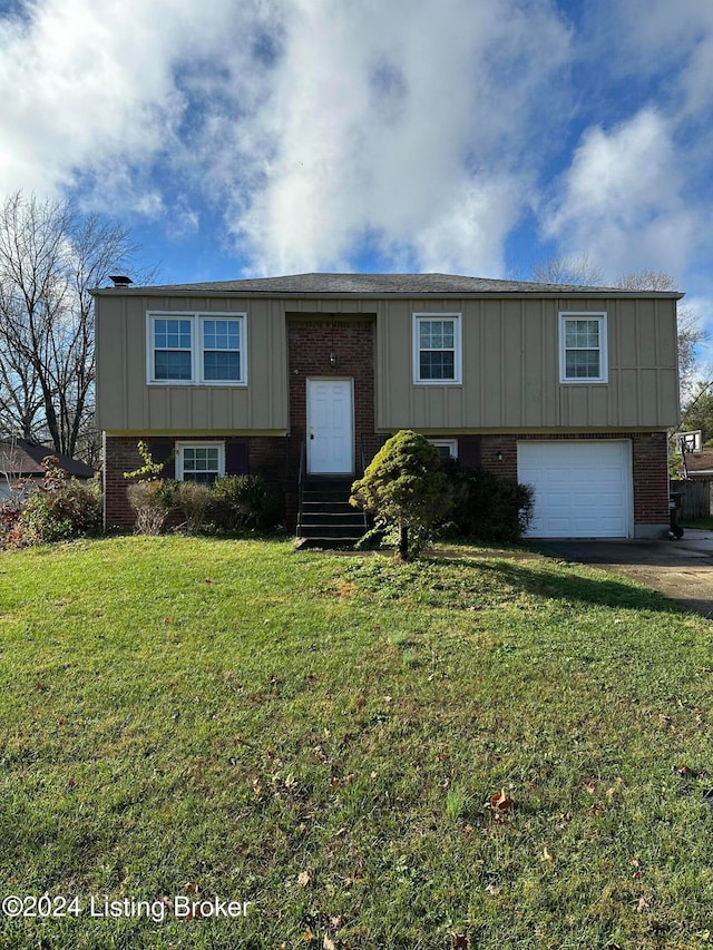 raised ranch with a garage and a front lawn