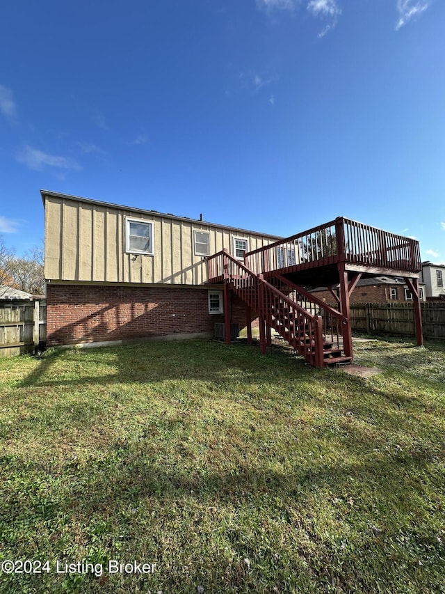 rear view of house with a lawn and a deck