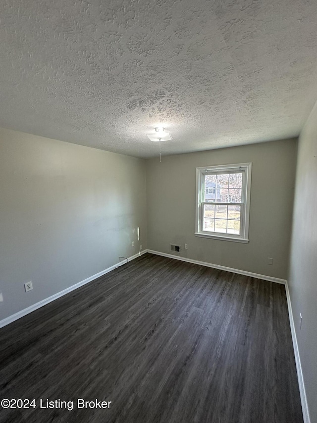 unfurnished room with dark hardwood / wood-style floors and a textured ceiling