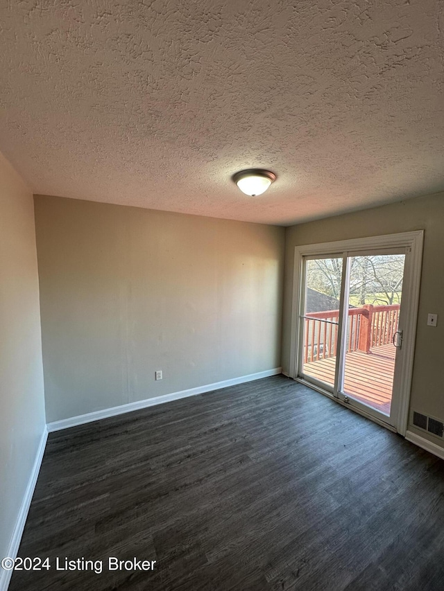 unfurnished room with dark hardwood / wood-style floors and a textured ceiling