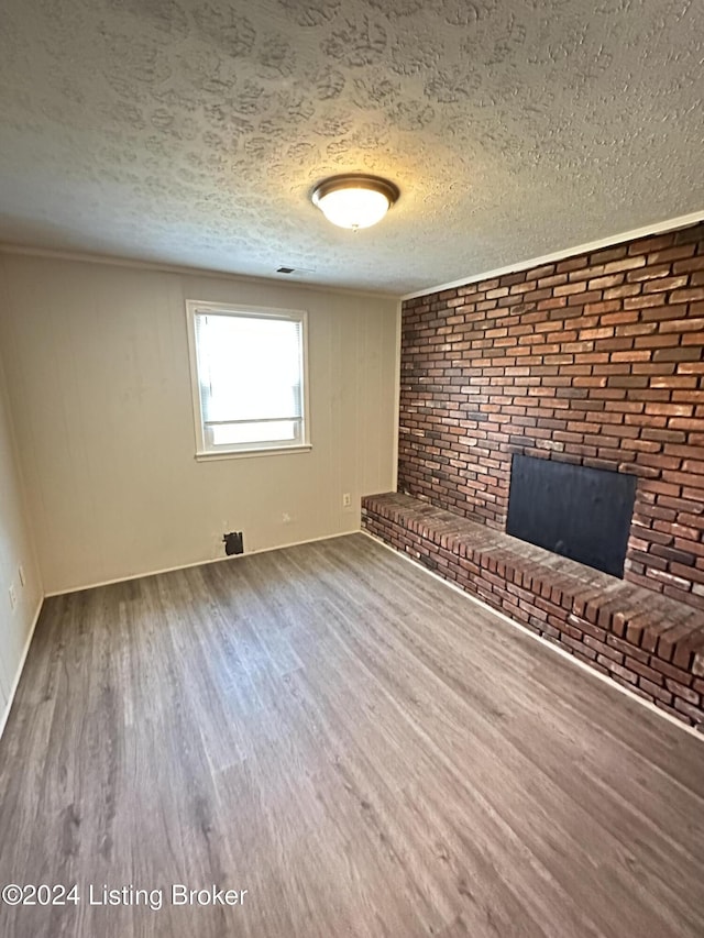 unfurnished living room featuring hardwood / wood-style flooring, a fireplace, and a textured ceiling