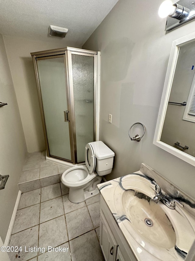 bathroom with vanity, tile patterned floors, toilet, a textured ceiling, and an enclosed shower