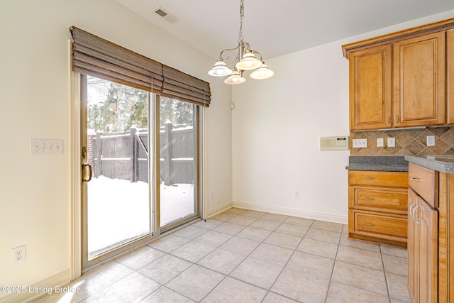 kitchen featuring an inviting chandelier, decorative light fixtures, light tile patterned flooring, and tasteful backsplash