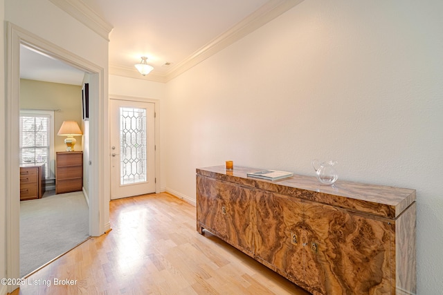 foyer with light hardwood / wood-style floors and ornamental molding