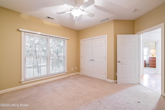 unfurnished bedroom featuring a closet, ceiling fan, and light carpet