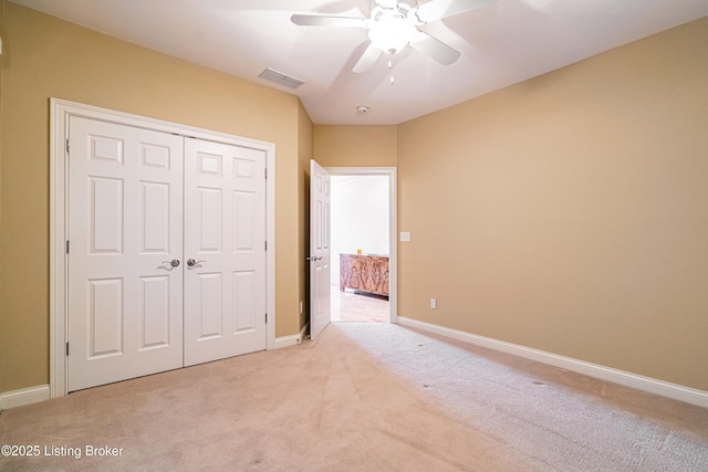 unfurnished bedroom featuring light colored carpet, a closet, and ceiling fan