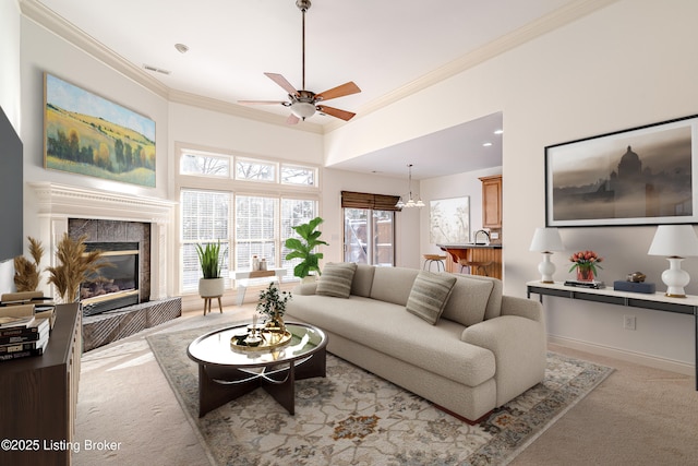 carpeted living room with ceiling fan, a fireplace, and ornamental molding