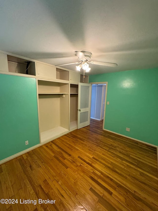 unfurnished bedroom featuring ceiling fan, wood-type flooring, and a closet