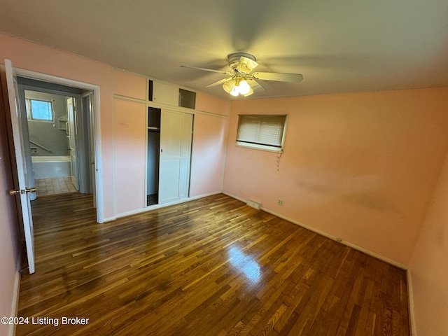 unfurnished bedroom featuring dark hardwood / wood-style flooring, a closet, and ceiling fan