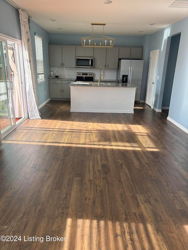 kitchen featuring gray cabinetry, sink, dark hardwood / wood-style floors, an island with sink, and stainless steel appliances