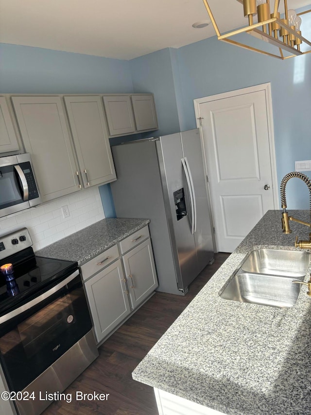 kitchen featuring light stone countertops, sink, stainless steel appliances, dark hardwood / wood-style flooring, and gray cabinets