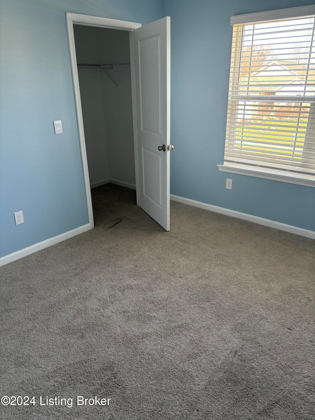 unfurnished bedroom featuring carpet floors and a closet