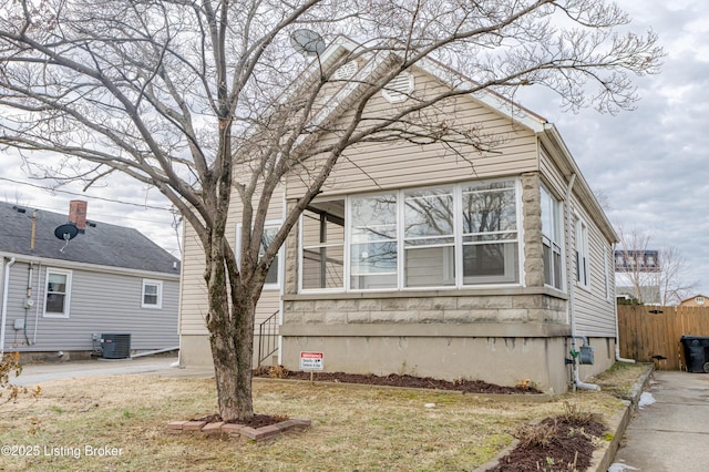 view of side of property featuring central AC and a lawn