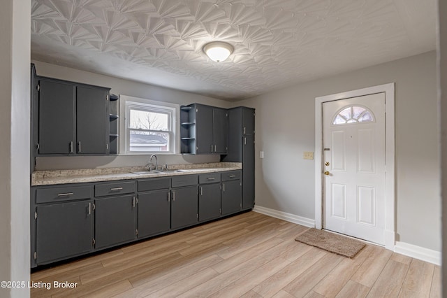 kitchen with sink, gray cabinetry, and light hardwood / wood-style floors