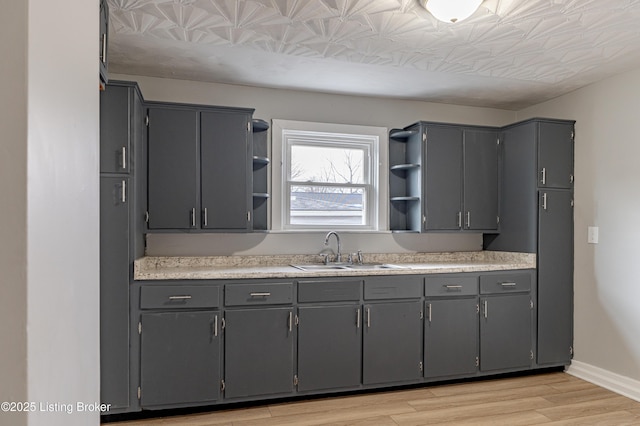 kitchen with gray cabinets, sink, and light hardwood / wood-style floors