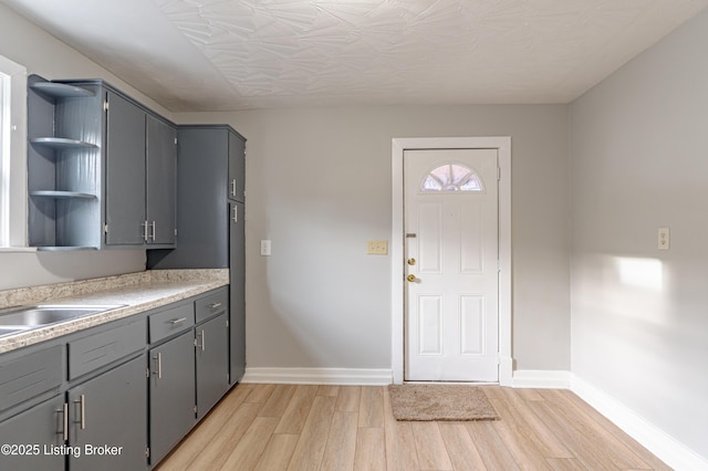 kitchen featuring sink, light hardwood / wood-style floors, and gray cabinetry