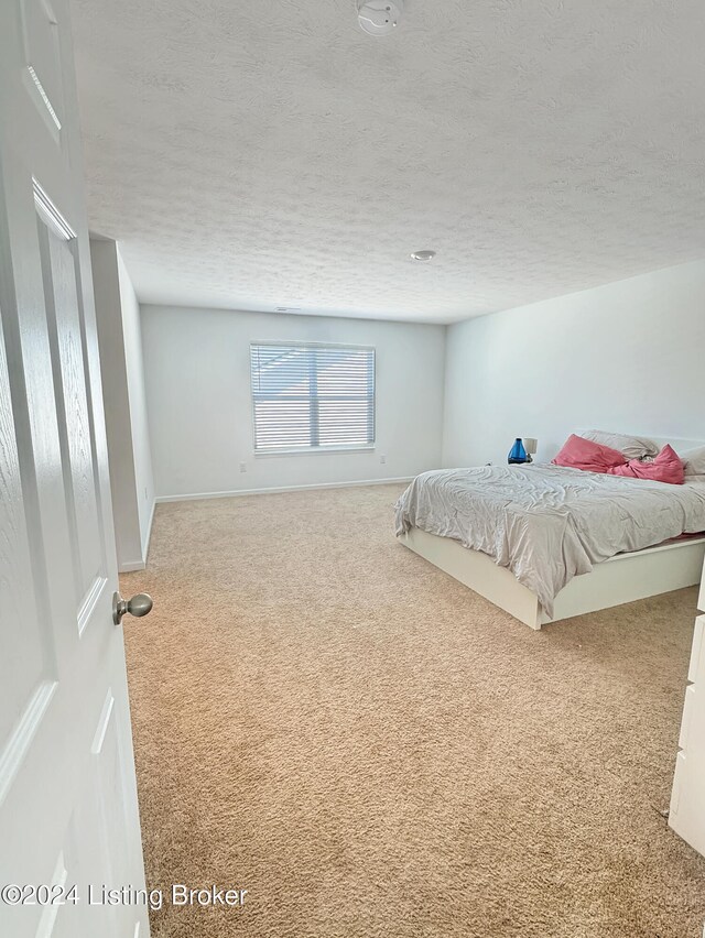 carpeted bedroom featuring a textured ceiling