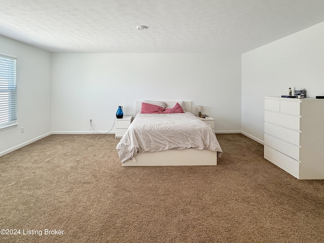 bedroom with light carpet and a textured ceiling