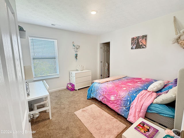 bedroom with light colored carpet and a textured ceiling