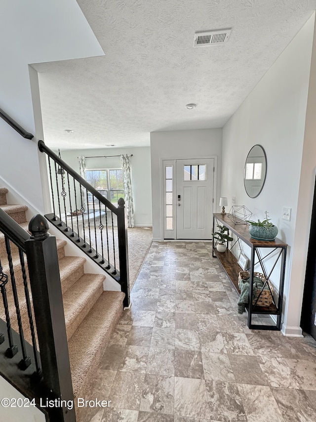 foyer entrance featuring a textured ceiling