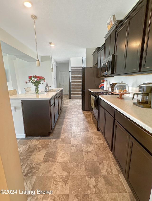 kitchen with appliances with stainless steel finishes, dark brown cabinetry, pendant lighting, and sink