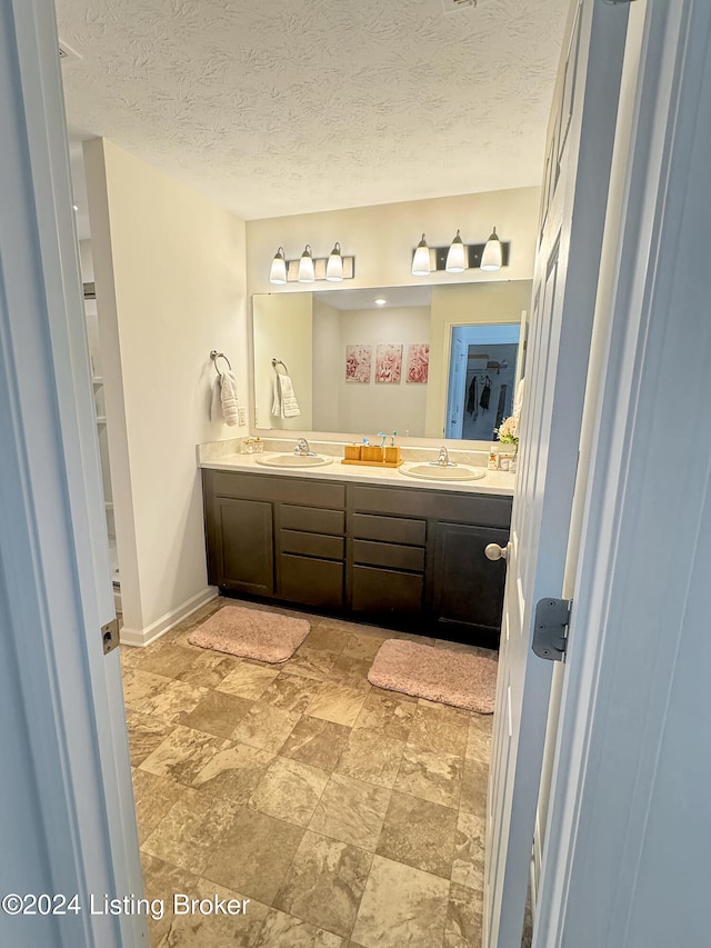 bathroom featuring a textured ceiling and vanity