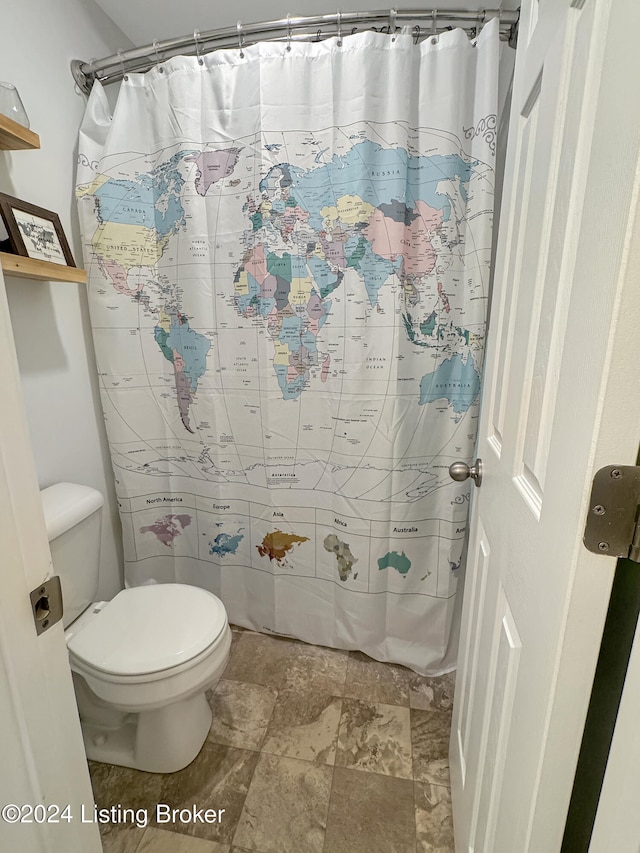 bathroom with a shower with curtain and toilet