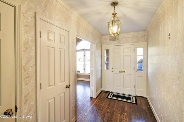 foyer featuring a notable chandelier, dark hardwood / wood-style floors, and ornamental molding