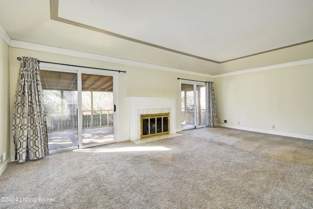 unfurnished living room featuring carpet flooring, ornamental molding, and a high end fireplace