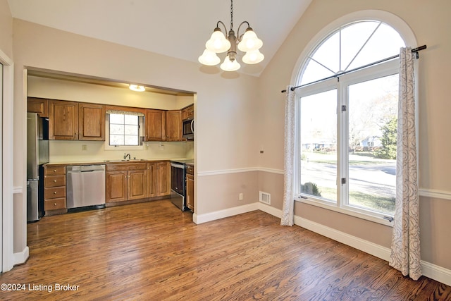 kitchen with sink, dark hardwood / wood-style flooring, a notable chandelier, vaulted ceiling, and appliances with stainless steel finishes