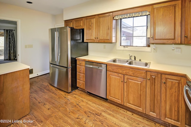 kitchen featuring stainless steel appliances, light hardwood / wood-style flooring, and sink