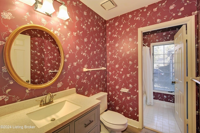 bathroom with tile patterned flooring, vanity, and toilet