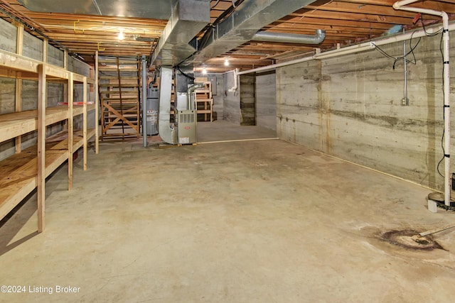 basement featuring heating unit and water heater