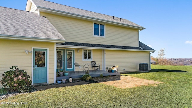 rear view of house featuring a yard and central air condition unit