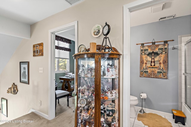 bathroom with tile patterned floors, toilet, and walk in shower