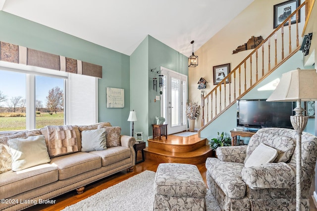 living room with a chandelier, hardwood / wood-style floors, and lofted ceiling