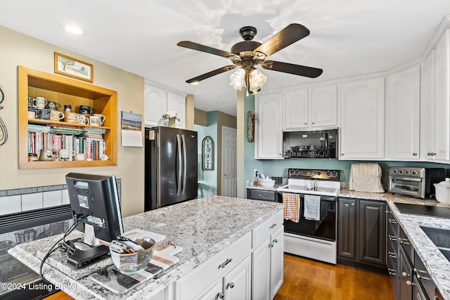 kitchen with white electric stove, white cabinetry, stainless steel refrigerator, and light stone counters