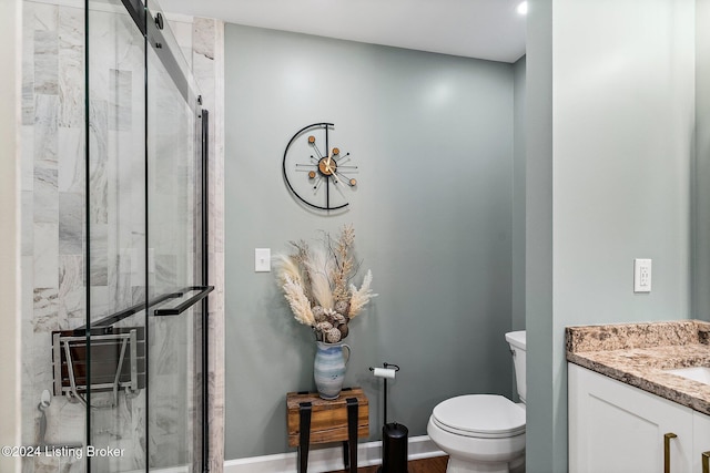 bathroom with vanity, an enclosed shower, and toilet