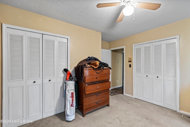 carpeted bedroom featuring a textured ceiling and ceiling fan