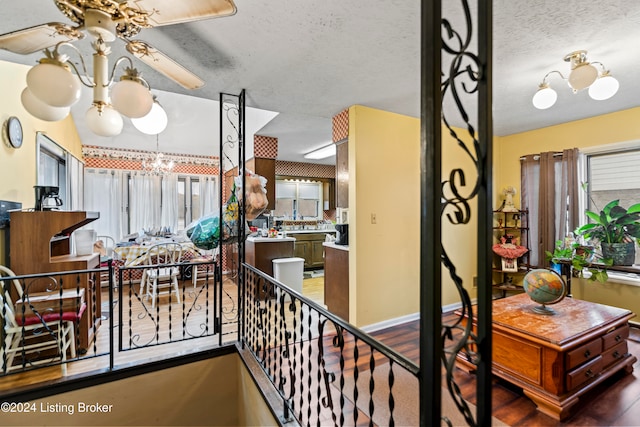 interior space with hardwood / wood-style floors, a textured ceiling, a wealth of natural light, and a chandelier