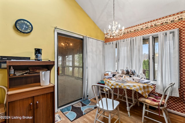 dining area with an inviting chandelier, lofted ceiling, and light wood-type flooring