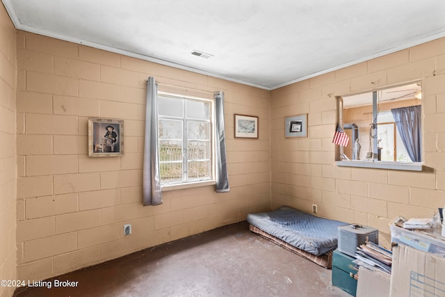 unfurnished bedroom with crown molding and concrete flooring