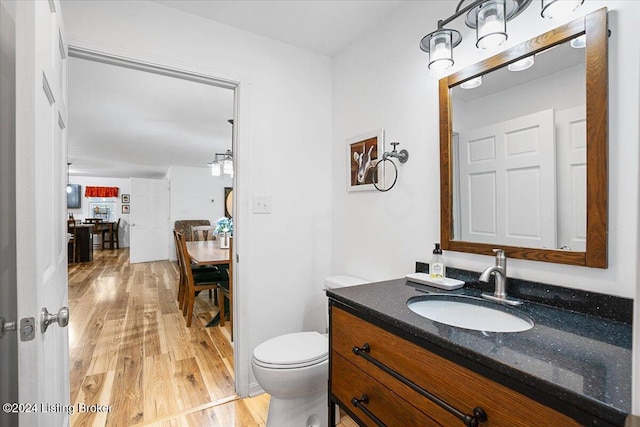 bathroom with vanity, toilet, and wood-type flooring