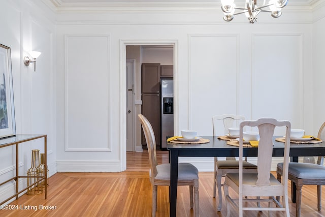 dining space with an inviting chandelier, light hardwood / wood-style flooring, and crown molding