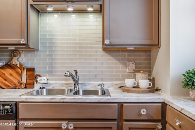 kitchen with tasteful backsplash, sink, and stainless steel dishwasher