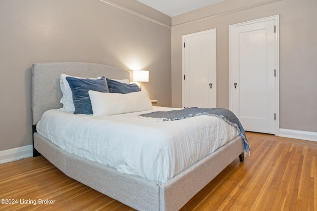 bedroom featuring hardwood / wood-style floors and multiple closets