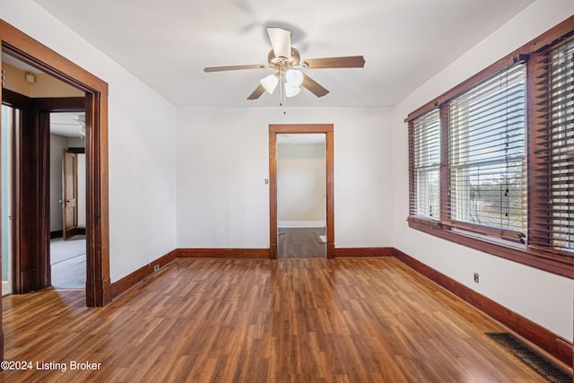 empty room with ceiling fan and dark wood-type flooring