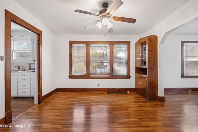 spare room featuring sink, dark wood-type flooring, plenty of natural light, and ceiling fan